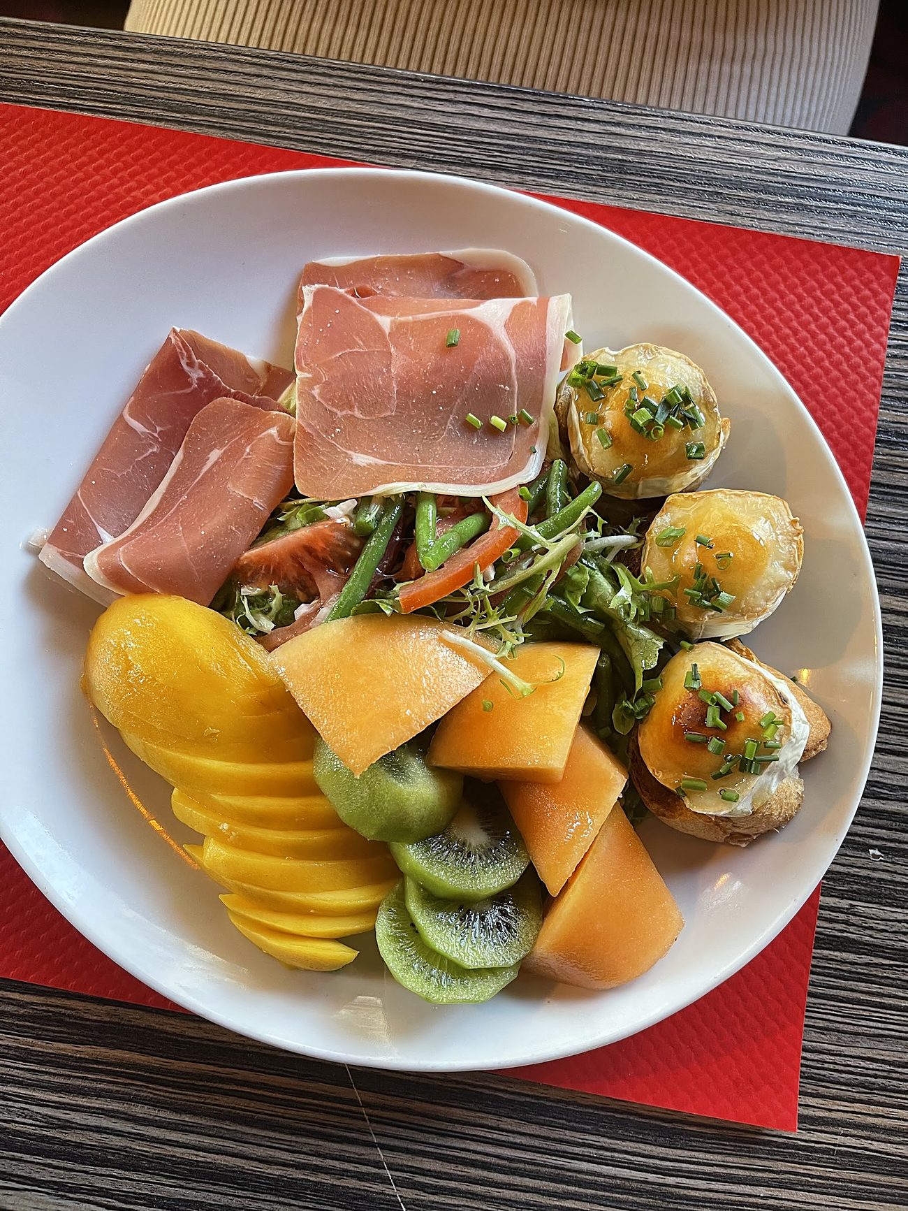 Chèvre chaud, jambon cru et fruits frais.