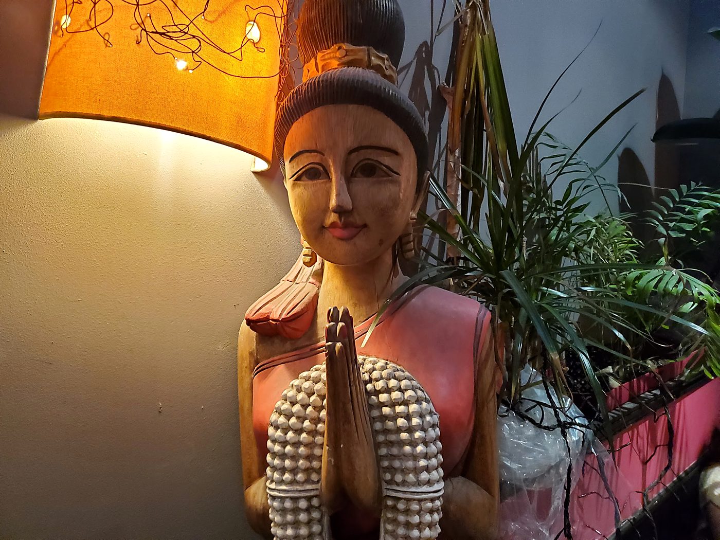 Statue en bois et lampe chaude, un détail du décor.