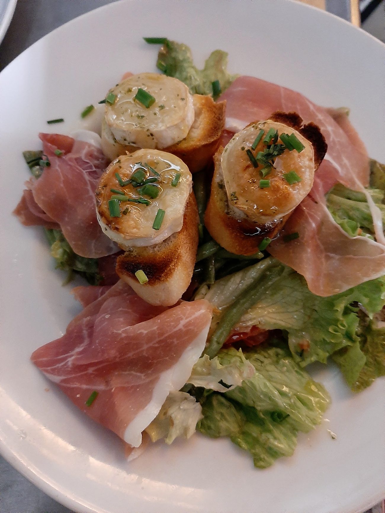 Toasts de chèvre gratinés et jambon cru.
