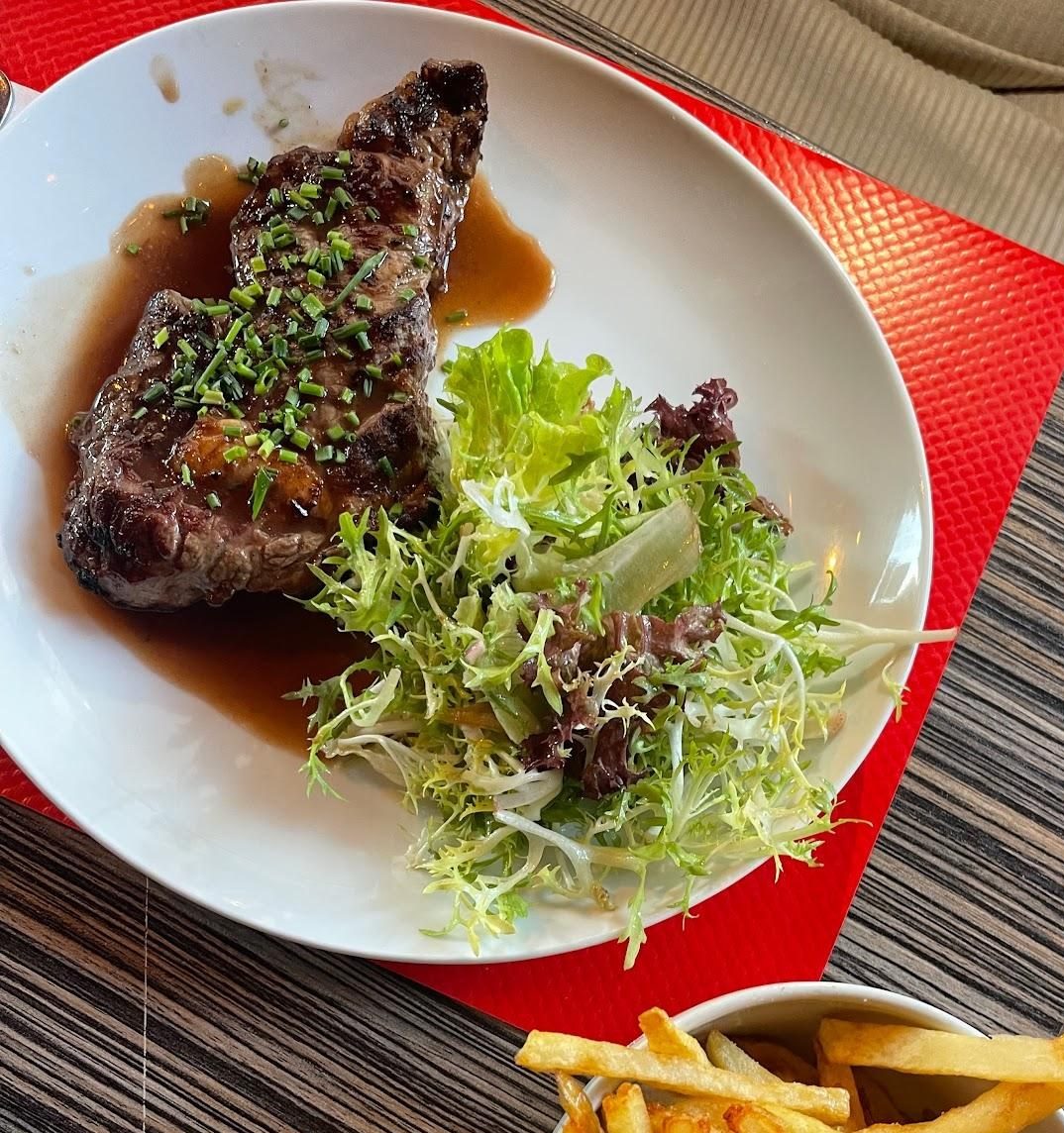Pièce du boucher et frites maison sur set rouge.